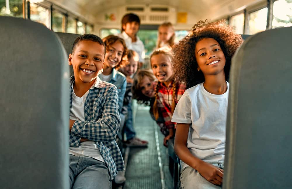 A group of children sitting on a excursion transport